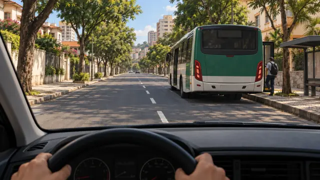 Ônibus junto ao ponto, passageiro na calçada e faixa ao lado aparentemente livre.